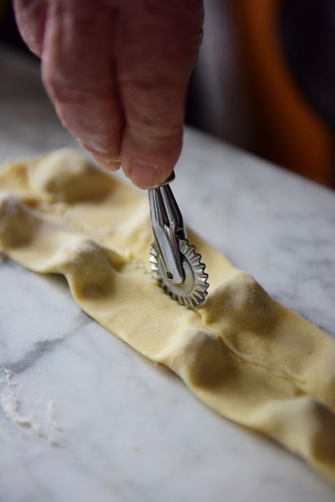 Separating pasta parcels using a pasta cutter wheel to make tortellini