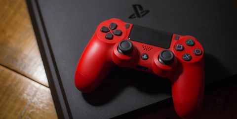 A Sony PlayStation 4 video game console with a red wireless