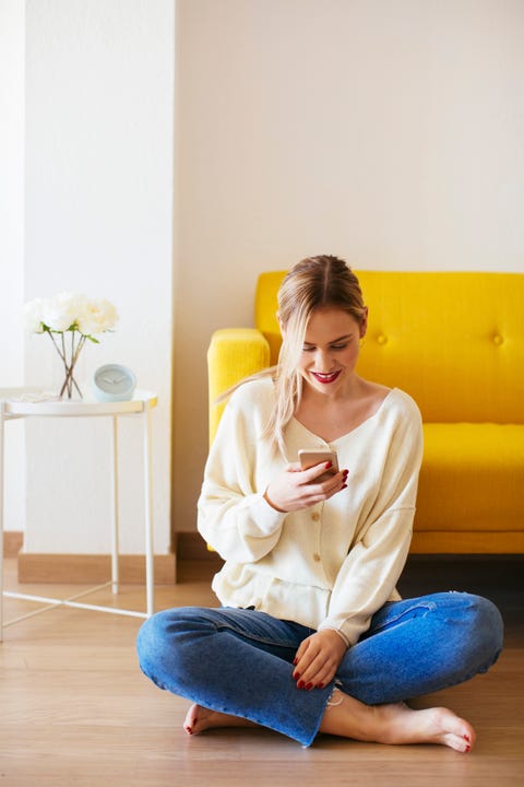 Blonde woman using smartphone at home