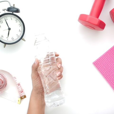Cropped Hand Holding Water Bottle By Objects Over White Background