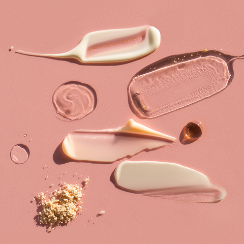 acne fighting creams and gels on a pink background