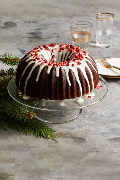 gingerbread bundt cake with pomegranate seeds and white icing on top
