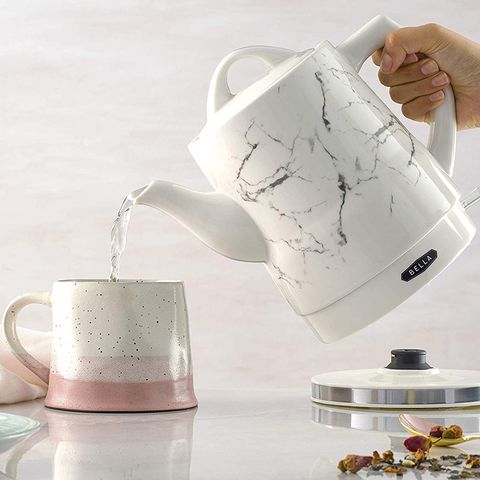 electric kettle pouring hot water into a cup