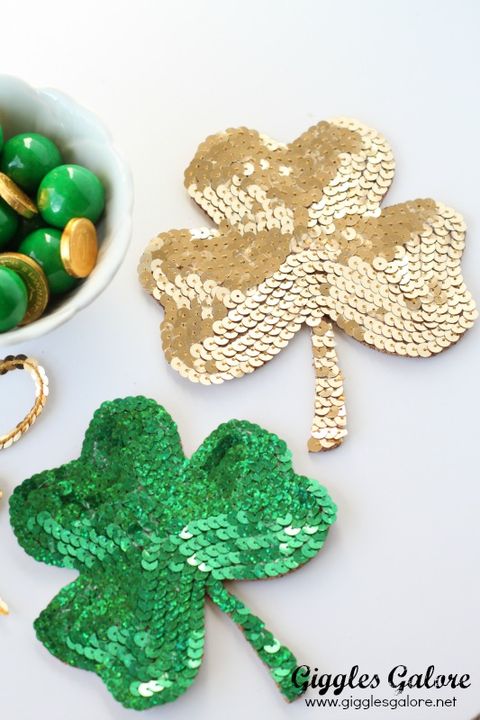 two sequined shamrock coasters, one green, one gold