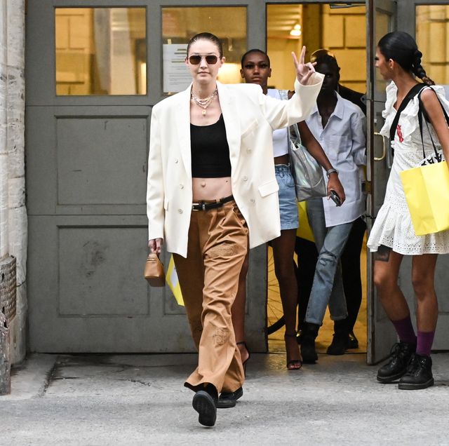 new york, new york   june 28 gigi hadid is seen wearing a white blazer, black crop top, brown pants and black converse sneakers outside the marc jacobs show on june 28, 2021 in new york city photo by daniel zuchnikgetty images