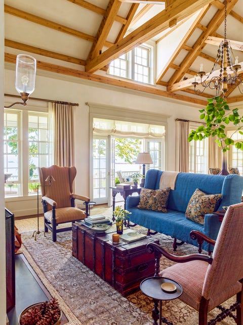 in the living room an antique needlepoint sofa is slipcovered in a cool ocean blue linen