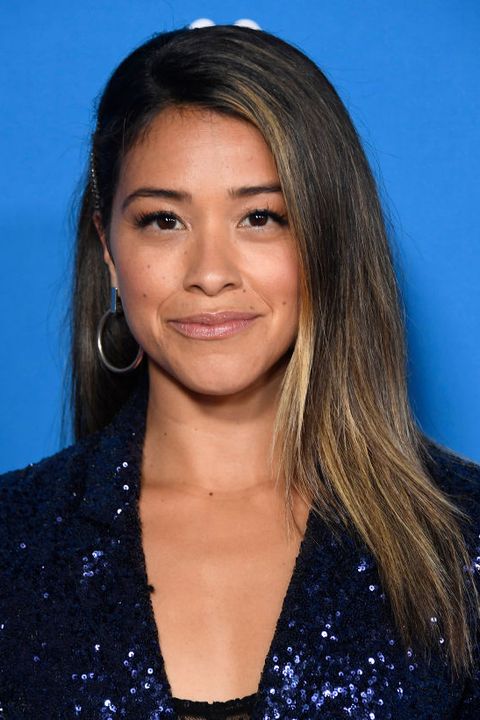 one fo the best wedding guest hairstyles, gina rodriguez's straight hair is up leveled with bronde money piece hair highlights