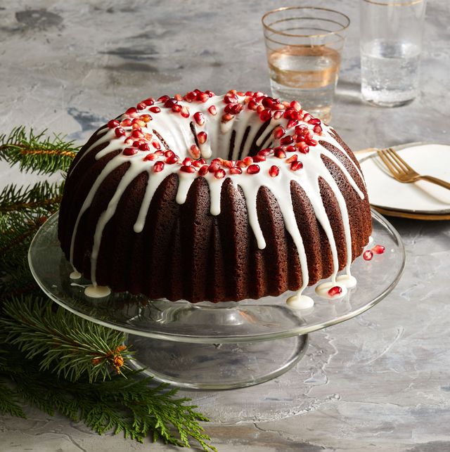 gingerbread bundt cake with pomegranate seeds and white icing on top