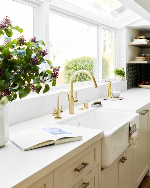 sink with gold faucet, cream cabinets with cream marble countertop