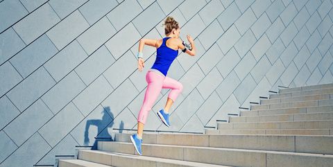 Girl is runing on the city stairs and listening the music