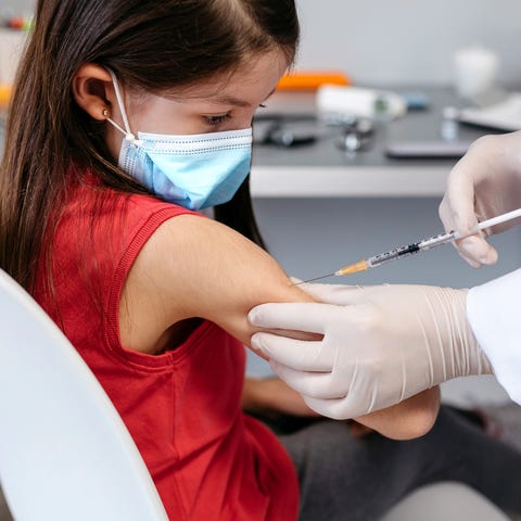 girl receiving coronavirus vaccine at doctor's office