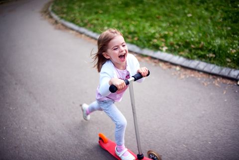 niña montando en patinete