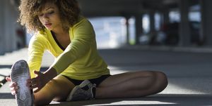 Girl stretching and listening to the music on her headphones