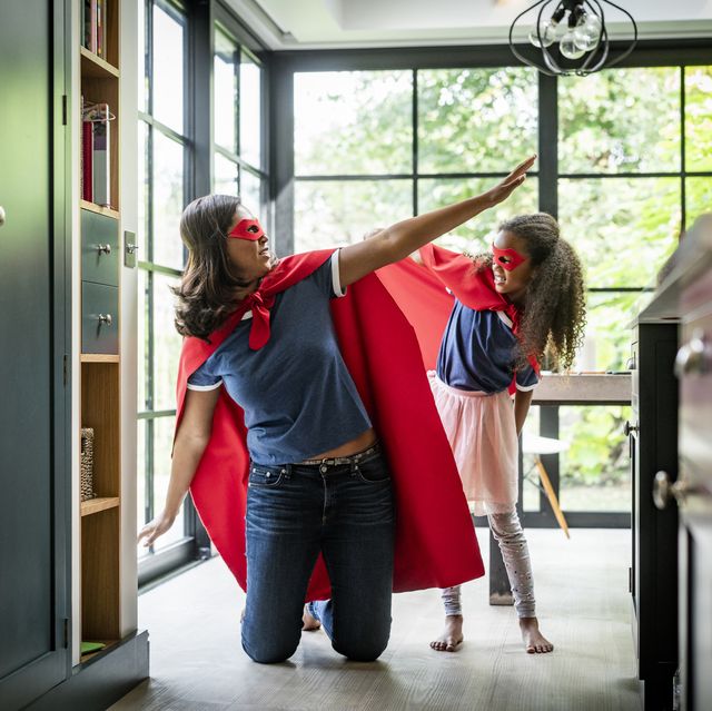 girl with mother in red superhero costume at home