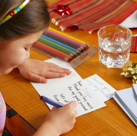 thanksgiving traditions - Girl writing Thank You card, smiling