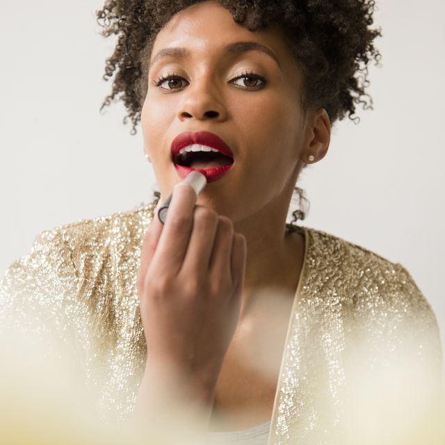black owned makeup brands glamorous black woman applying red lipstick