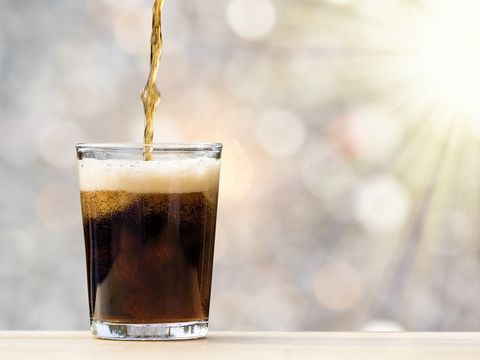 glass of drink with cola illuminated by sunlight