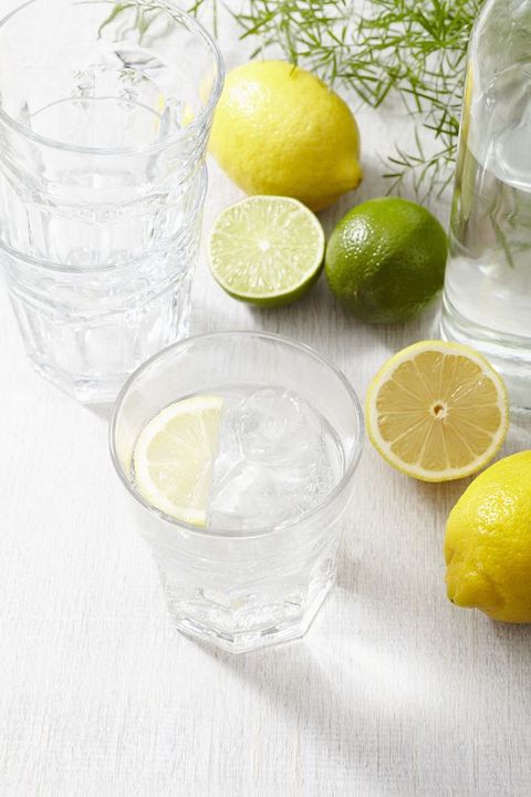 A glass of iced water with lemons and limes
