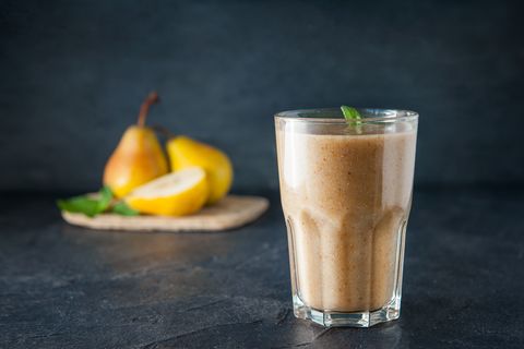 Glass of pear fruit smoothie with mint leaves and ingridients on the dark background. Healthy, vegetarian, vegan diet food. Selective focus, space for text.