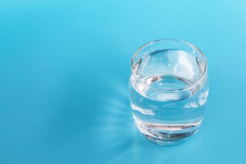 A glass of water on a blue background.