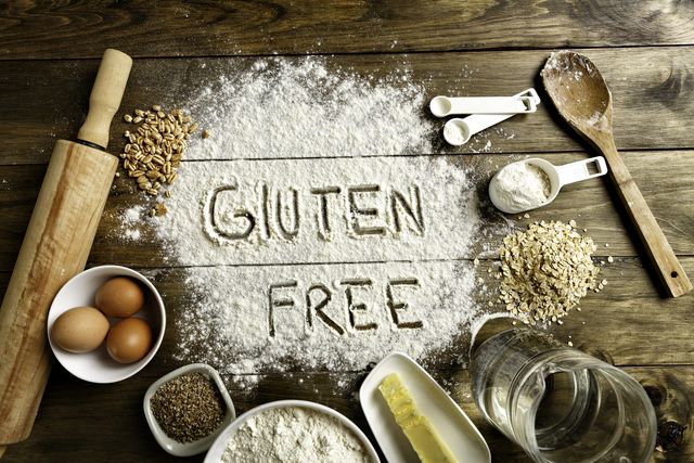 gluten free bread ingredients and utensils on wood frame background