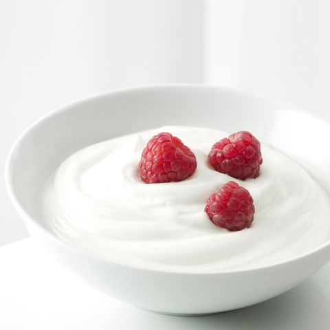 Yogurt with raspberries in a white bowl