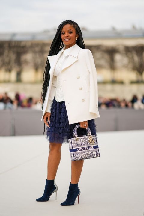 paris, france   march 01 a guest wears large pearls earrings, a white shirt, a white blazer jacket, a navy blue ruffled tulle short skirt, a white and navy blue print pattern lady d lite hand bag from dior, silver and diamonds rings, navy blue suede pointed heels ankle boots, outside dior, during paris fashion week   womenswear fw 2022 2023, on march 01, 2022 in paris, france photo by edward berthelotgetty images