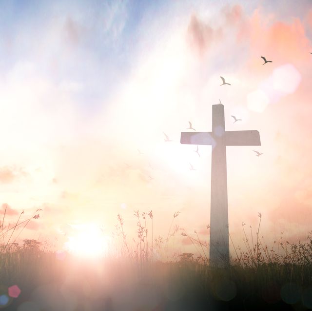 prayer for strength scenic shot of a cross in a meadow with a pink and blue cloudy sky and birds flying above
