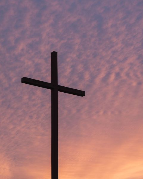silhouette of cross against sunset