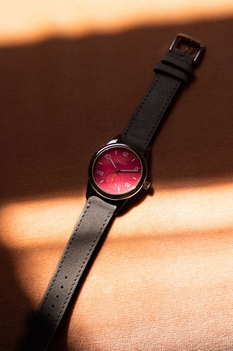 nomos watch laying on fabric with pink dial