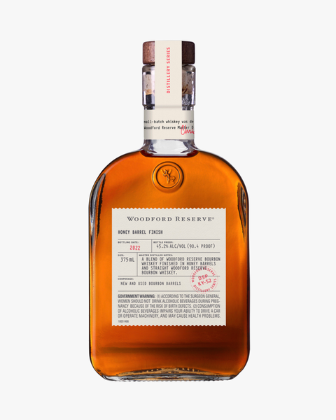 a bottle of woodford reserve honey barrel finish bourbon whiskey on a white background