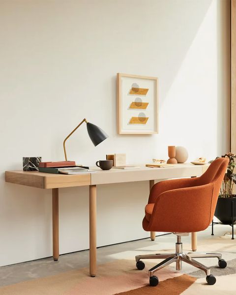 a desk with an orange chair in an office