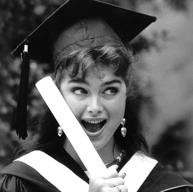 a woman in a cap and gown holding her diploma