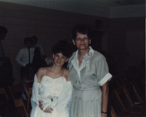 the author pictured at her 8th grade graduation wears a white dress and stands next to her grandmother both are smiling