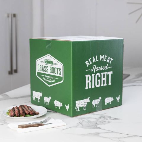 a green cardboard box with grass roots on it and a plate of meat