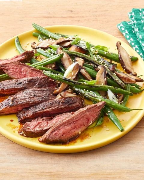 skirt steak with blistered green beans on yellow plate