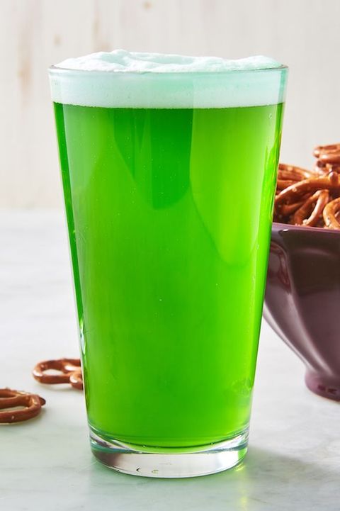 pint of green beer surrounded by pretzels