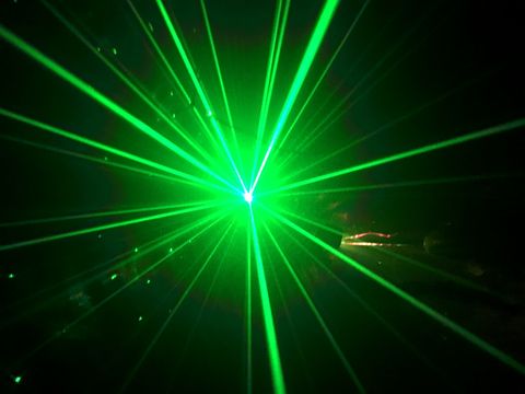 green colored laser light in a dark room