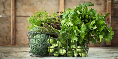 Verduras verdes y hierbas en cesta de alambre Verduras verdes y hierbas en cesta de alambre