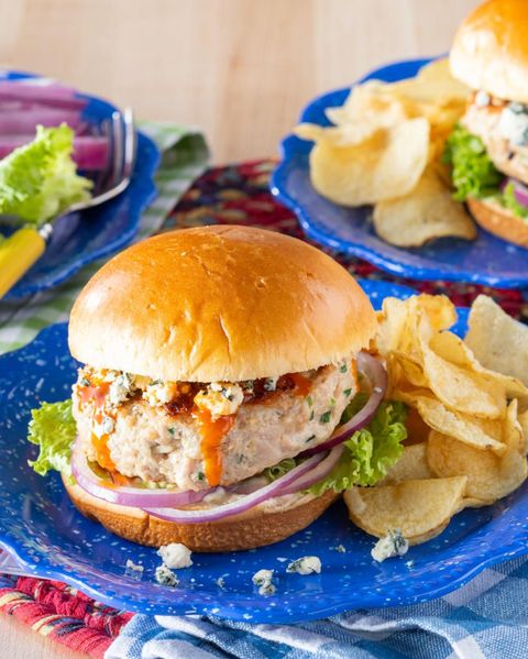 homemade chicken burgers on blue plate with potato chips