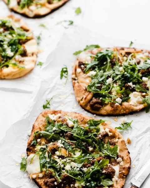 grilled lamb pizzas with arugula on paper