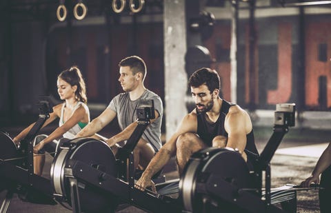 A group of athletes exercising with rowing machines in the gym A group of athletes exercising with rowing machines in the gym