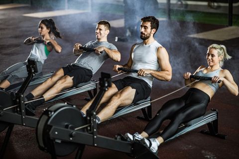 A group of athletes exercising with rowing machines in the gym
