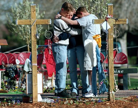 A group of Columbine students gather around crosses at Chapel Hill Memorial Gardens during the 11:21 am moment of silence on the one year anniversary of the Columbine High School Shootings. 