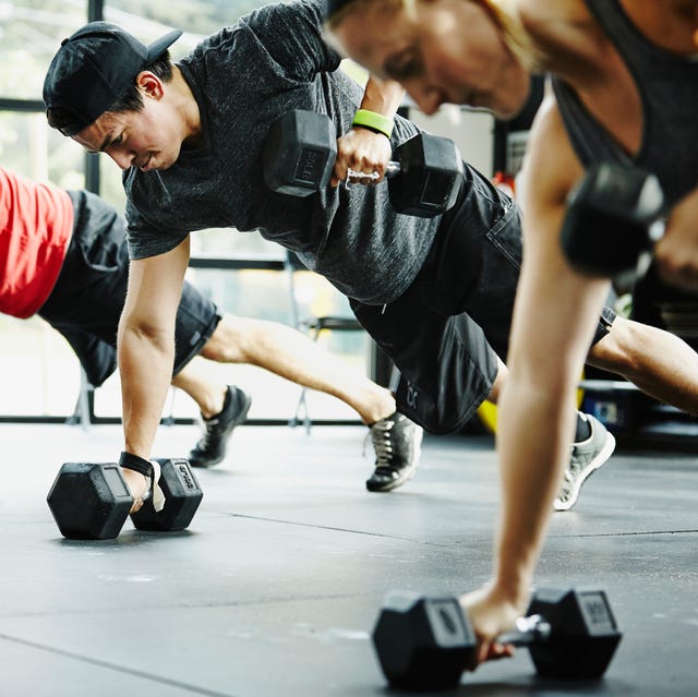 Group of friends doing pushups with dumbbells group of friends doing pushups with dumbbells