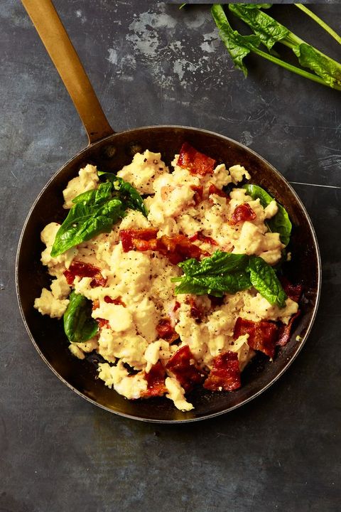 gruyère, bacon, and spinach scrambled eggs in a pan