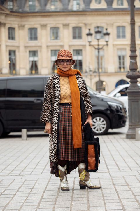 oudere vrouw in meerdere prints op straat tijdens fashion week