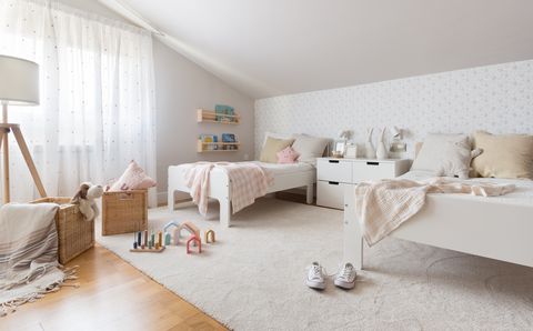 habitación infantil abuhardillada decorada en blanco con dos camas