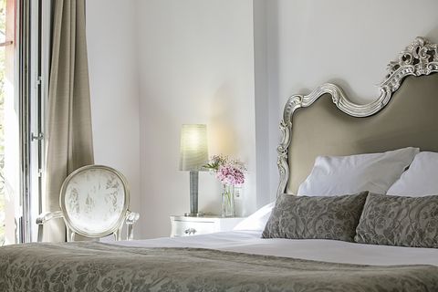 cama, cabecero y silla y tapizada de unas de las habitaciones de este hotel de lujo de madrid
