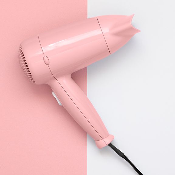 Pink hair dryer on pink and white background